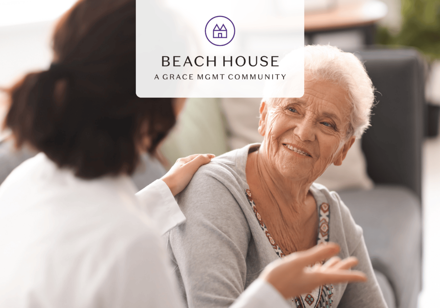 Smiling elderly woman with a caregiver's hand on her shoulder; Beach House logo overlay at the top center.